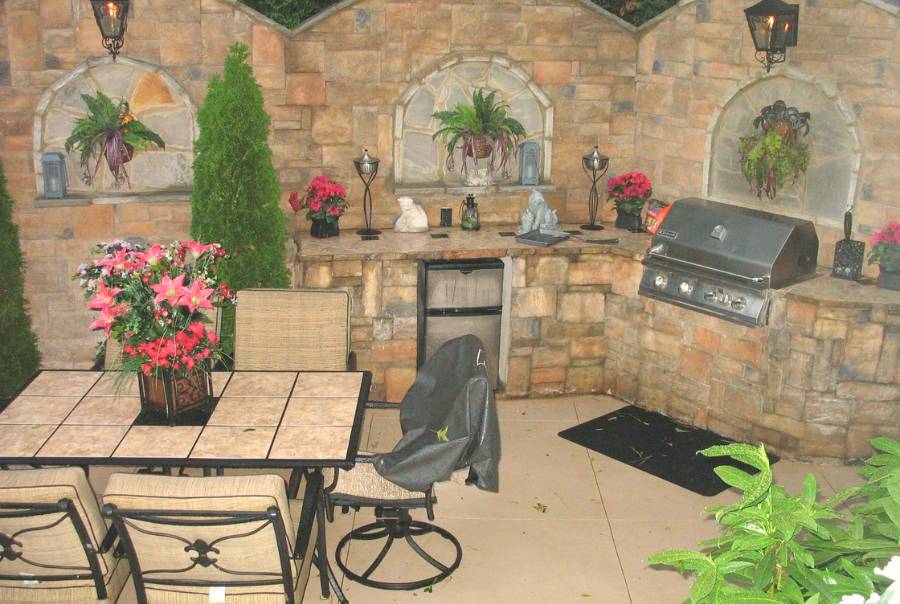 Outdoor Patio Kitchen With Stone Grill Area And Dining Set